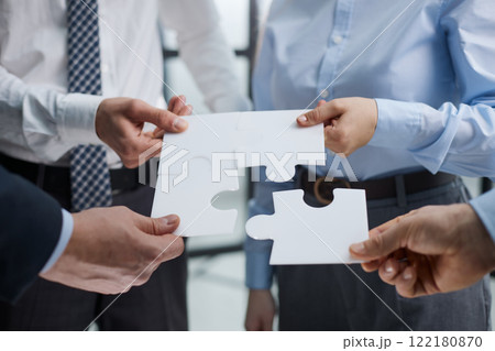 The team assembles the puzzle while standing in the office The team assembles the puzzle while standing in the office 122180870