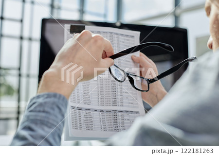 A male manager is reviewing marketing reports for the new campaign 122181263