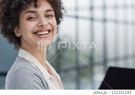 Young Stylish Female with Curly Hair Using Laptop 122181291