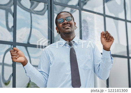 man in a modern office listening to music with white headphones 122181300