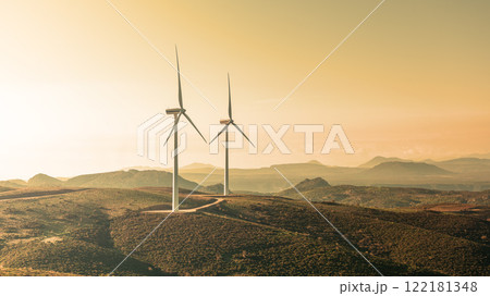 Turbines in a mountain wind farm at sunset. Ecological energy production. 122181348