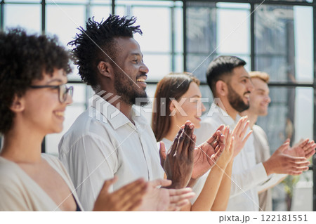 Group of businesspeople sitting in a line and applauding. Group of businesspeople sitting in a line and applauding. 122181551