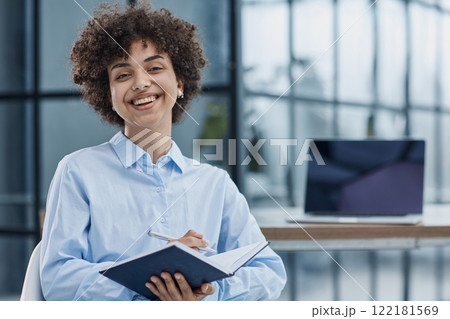Happy female designer standing in office Happy female designer standing in office 122181569