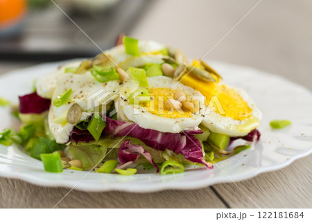 Homemade salad with greens in a plate on a wooden table 122181684