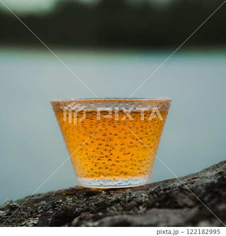 Enjoying a golden beverage displayed beautifully in a rustic and picturesque setting Enjoying a golden beverage displayed beautifully in a rustic and picturesque setting 122182995