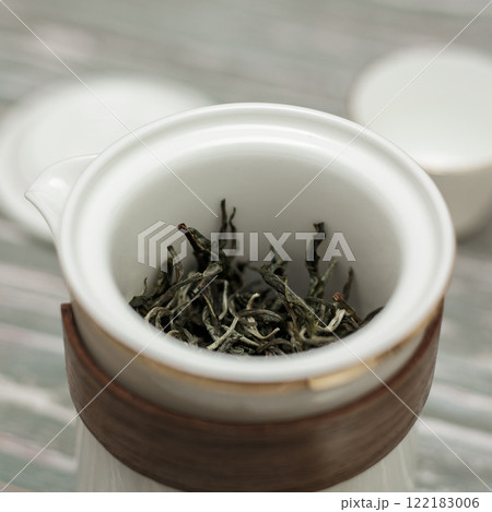 An Elegant Teapot Displaying Fresh Green Tea Leaves Ready for Brewing a Delicious Drink 122183006