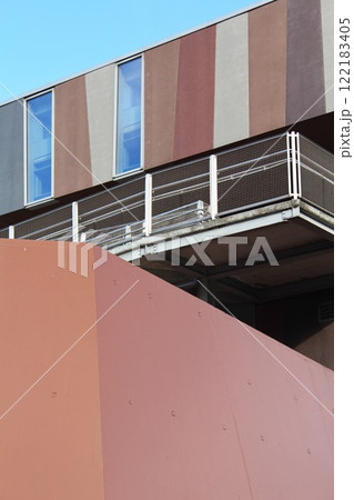 abstract fragment of an exterior view of modern architecture building in the city against a blue sky, wall of futuristic facade of urban development 122183405