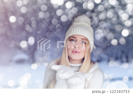 Blonde woman wearing warm mittens, knitted beanie hat and jumper, winter snow nature background with copyspace fashion and lifestyle idea 122183753