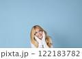 Winter portrait on blue background, happy blonde woman wearing warm mittens and knitted jumper, fashion and lifestyle idea 122183782