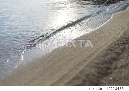calm sea wave illuminated by the sun on a sandy beach on the seashore calm sea wave illuminated by the sun on a sandy beach on the seashore 122184284
