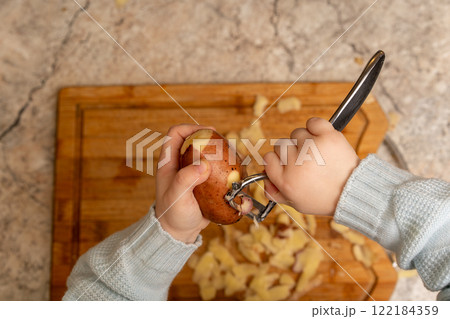 Child Peeling Potato 122184359