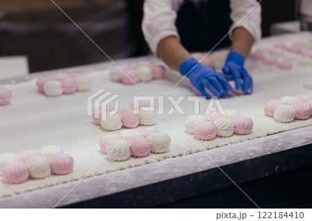 Woman in gloves packing zefir on confectionery industry line 122184410