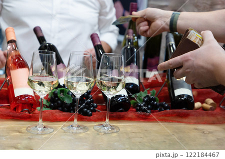 buyer's hand taking a bottle of wine from stand buyer's hand taking a bottle of wine from stand 122184467