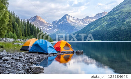 Colorful tents by a serene lake surrounded by majestic mountains in a tranquil camping setting 122184648