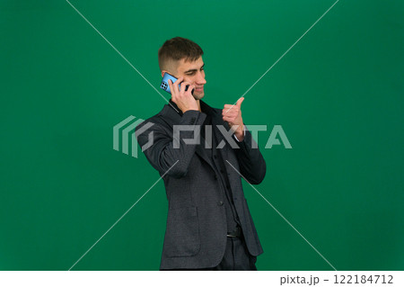 Positive man hold mobile smile and show thumb up confident face isolated 122184712