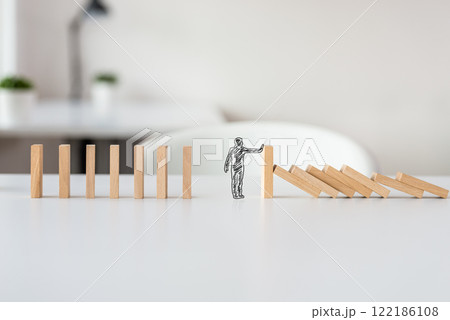 Hand drawn shape of businessman stopping domino effect 122186108