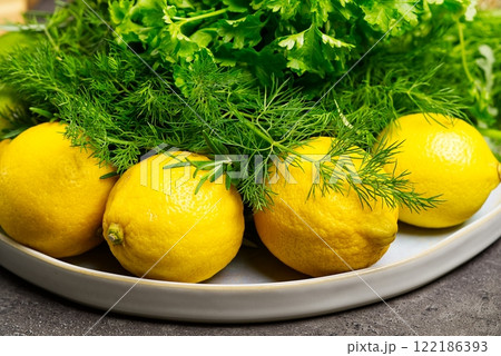 Bright Yellow Lemons and Fresh Dill Weed Closeup on Grey Stone Background for Healthy Recipes Bright Yellow Lemons and Fresh Dill Weed Closeup on Grey Stone Background for Healthy Recipes 122186393