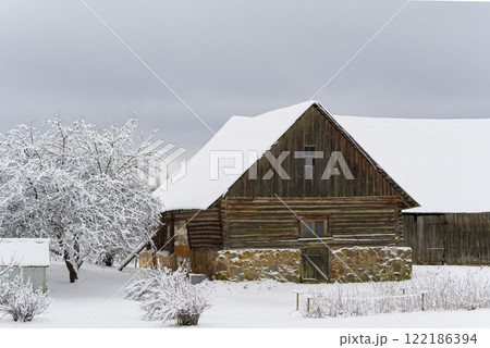 A Beautiful Rustic Wooden Barn in a Snowy Field Under a Cloudy Winter Sky on a Chilly Day A Beautiful Rustic Wooden Barn in a Snowy Field Under a Cloudy Winter Sky on a Chilly Day 122186394