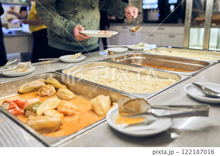A volunteer provides hot food for the poor. The concept of food in a charity canteen. With space to copy. High quality photo A volunteer provides hot food for the poor. The concept of food in a charity canteen. With space to copy. High quality photo 122187016
