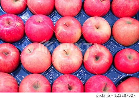 スーパーで販売されているモウルドパックに並べられた赤いリンゴ 122187327