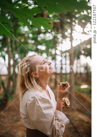 Young woman enjoying a moment of joy outdoors among the trees during daytime in a forest 122187507