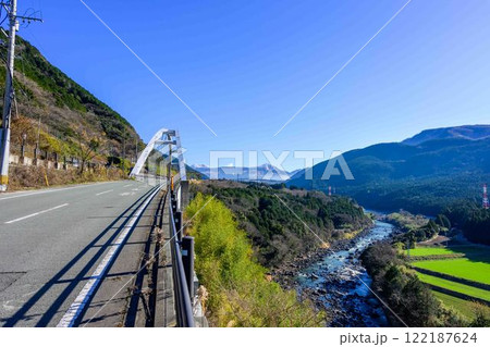積雪の阿蘇山を背景に田園と山並みを流れる白川風景(菊池郡大津町外牧・瀬田地区) 122187624