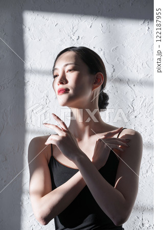 日差しのシルエットやハイライトが美しいスキンケアをする若い女性 122187955