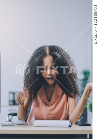 Young caucasian business woman counting funds, planning budget, paying bills online using calculator. Freelancer boss CEO doing paperwork with finances. Young caucasian business woman counting funds, planning budget, paying bills online using calculator. Freelancer boss CEO doing paperwork with finances. 122188753