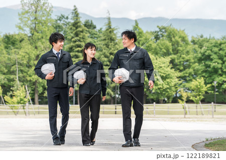 公園を歩く造園業・土木業の作業着姿の男女の作業員 122189821