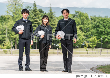 公園に立つ造園業・土木業の作業着姿の男女の作業員 122189824