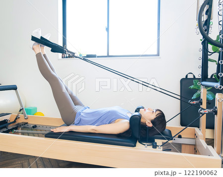 マシンピラティスのトレーニングをする女性 マシンピラティスのトレーニングをする女性 122190062