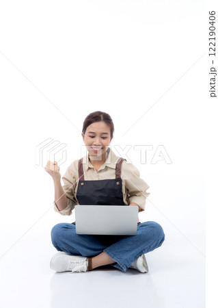Portrait young asian business woman wearing apron holding laptop computer isolated. Portrait young asian business woman wearing apron holding laptop computer isolated. 122190406