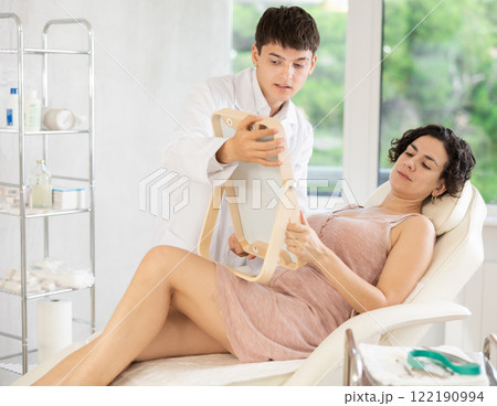 Cosmetologist examining face of woman and planning face lifting procedures Cosmetologist examining face of woman and planning face lifting procedures 122190994