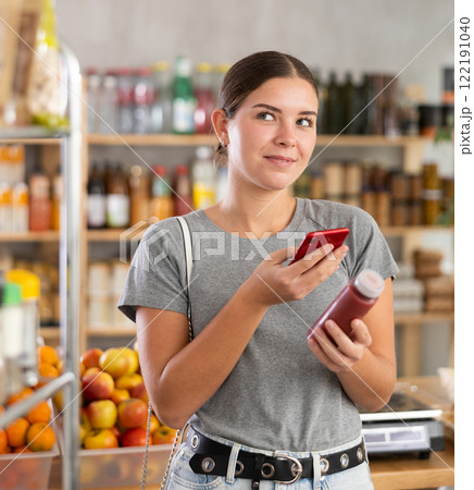 Woman scans code on smoothie bottle 122191040
