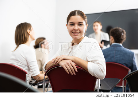 Young smiling woman attending lecture in university 122191054