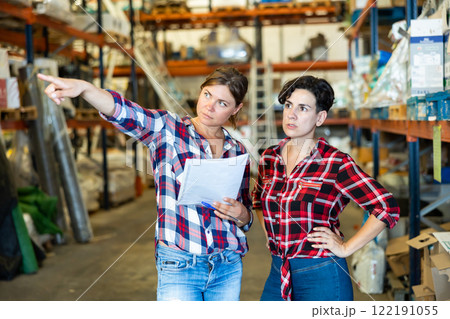 Women dicsussing stock control in warehouse Women dicsussing stock control in warehouse 122191055