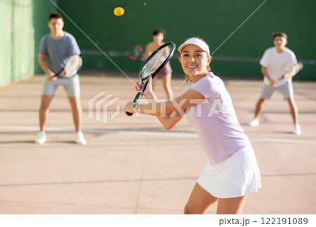 Woman pelota player hitting ball with racket Woman pelota player hitting ball with racket 122191089