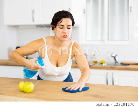 Positive woman keeping home clean and fresh during day, cleaning kitchen table Positive woman keeping home clean and fresh during day, cleaning kitchen table 122191170