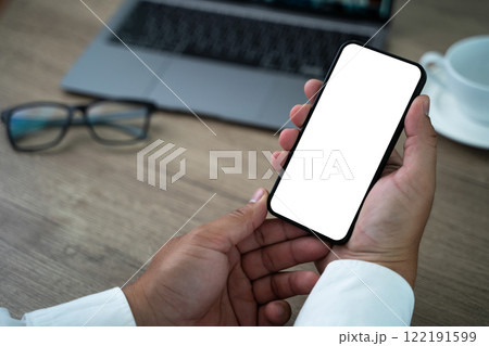 A man is holding a cell phone with a white screen 122191599
