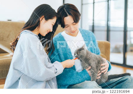 猫におやつをあげるカップル 猫におやつをあげるカップル 122191694