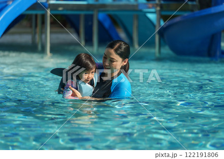 toddler baby girl in life jacket playing water splashing in swimming pool 122191806