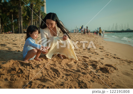 happy toddler baby girl playing sand with mother on sea beach in Pattaya, Thailand 122191808