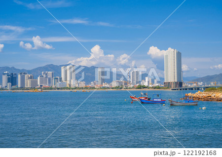 View from the sea of fishing boats and the Vietnamese city of Nha Trang on a sunny cloudy day View from the sea of fishing boats and the Vietnamese city of Nha Trang on a sunny cloudy day 122192168