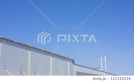 Factory industry, Warehouse Construction in Geometric Modern Design, Backdrop Wall Metal Corrugated Steel Surface Pattern, Architecture Building with Aluminium Facade on Blue Sky Background. Factory industry, Warehouse Construction in Geometric Modern Design, Backdrop Wall Metal Corrugated Steel Surface Pattern, Architecture Building with Aluminium Facade on Blue Sky Background. 122192819