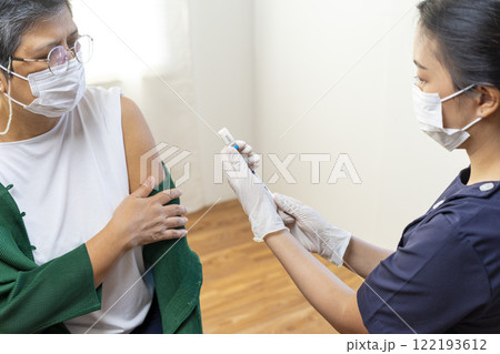 Elderly Asian woman getting coronavirus vaccine by nurse. Medical worker prepare syringe. Elderly Asian woman getting coronavirus vaccine by nurse. Medical worker prepare syringe. 122193612