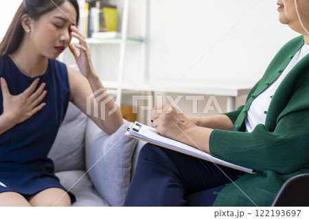 Asian psychologist doctor having session with young depressed woman in clinic. Psychology and mental therapy concept. 122193697