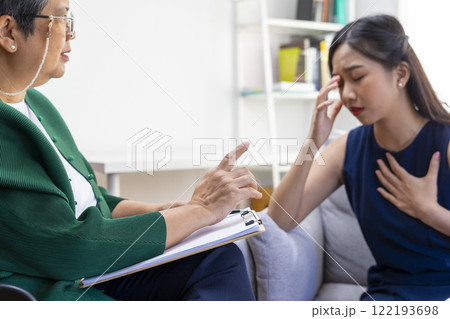 Asian psychologist doctor having session with young depressed woman in clinic. Psychology and mental therapy concept. 122193698