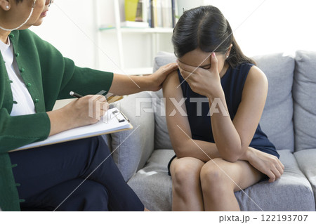 Asian psychologist doctor having session with young depressed woman in clinic. Psychology and mental therapy concept. Asian psychologist doctor having session with young depressed woman in clinic. Psychology and mental therapy concept. 122193707