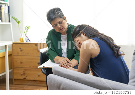 Asian psychologist doctor having session with young depressed woman in clinic. Psychology and mental therapy concept. 122193755