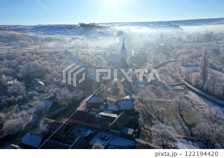 Morning sunrise lights and mist, fog over village church tower aerial view 122194420